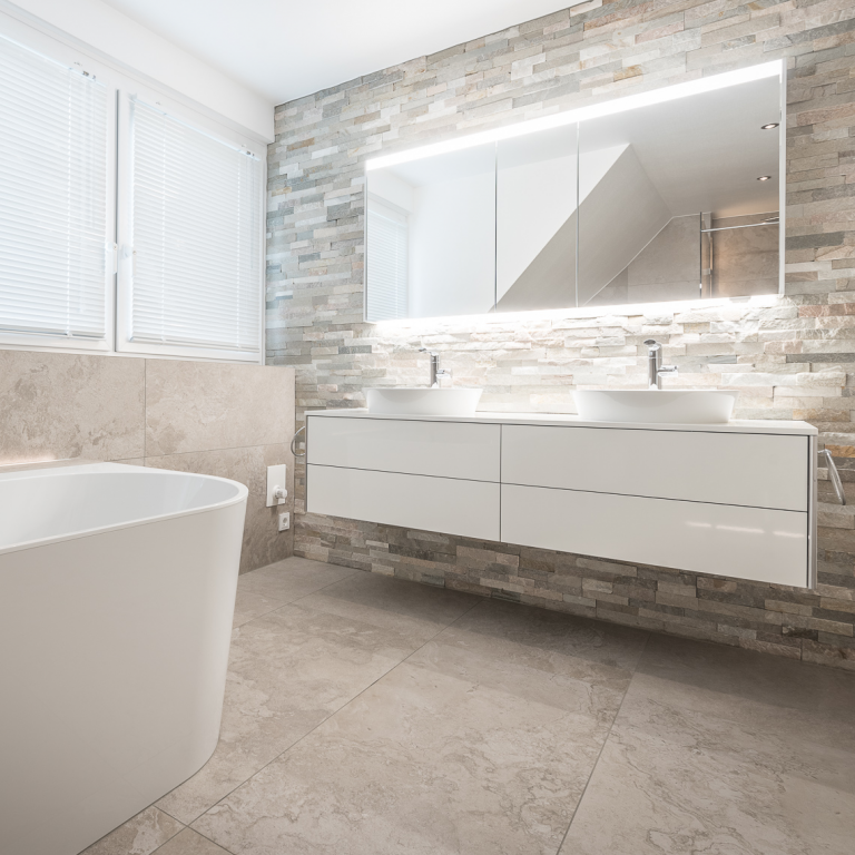 Badezimmer mit Fliesen in Natursteinoptik und elegantem Waschtisch