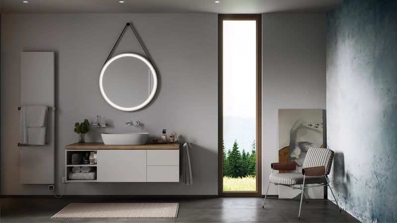 Modernes Badezimmer mit rundem LED-Spiegel, Waschplatz mit Aufsatzbecken, Handtuchheizkörper und minimalistischer Möblierung – concept 100 Serie im klaren Design.